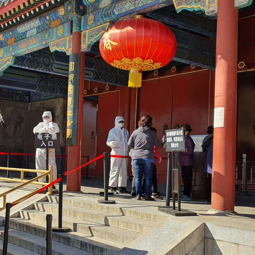 Two men in HAZMAT suits checking the temperatures of guests to the Old Summer Palace